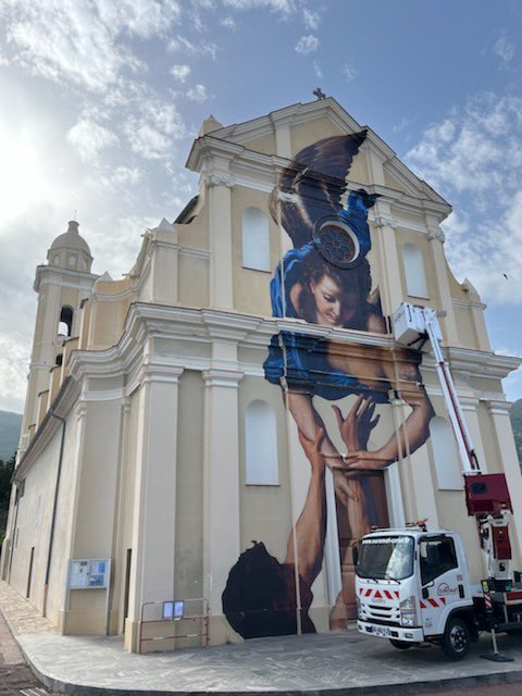Work in progress… l’installation de la fresque éphémère de Julien de Casabianca touche à sa fin sur la façade de Santa Lucia. <a href="/bastiatourisme/">Bastia Tourisme</a> « In Giru » été 2022.