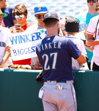 Jesse Winker signs the back of a young Mariners fan's jersey before today's game.