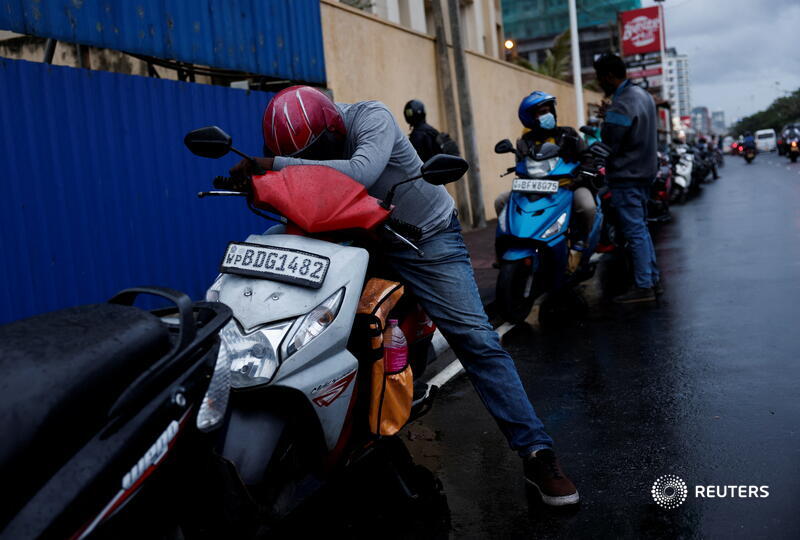 Reuters's tweet photo. Troops in Sri Lanka handed tokens to people lining up for gasoline amid a severe fuel shortage in the nation battling its worst economic crisis in seven decades https://t.co/jNaSOqTvMf https://t.co/o6u2Dw1YT8