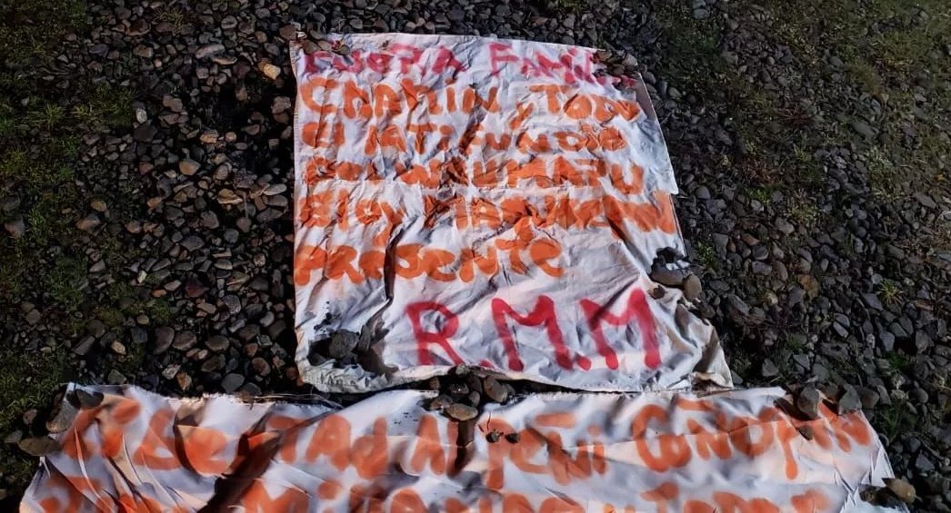 two canvases on the floor, first one reads : « Fuera familia Chahin y todo el latifundio del Wallmapu. Elon Manquepan presente. RMM. » ; second one is cropped by the picture 