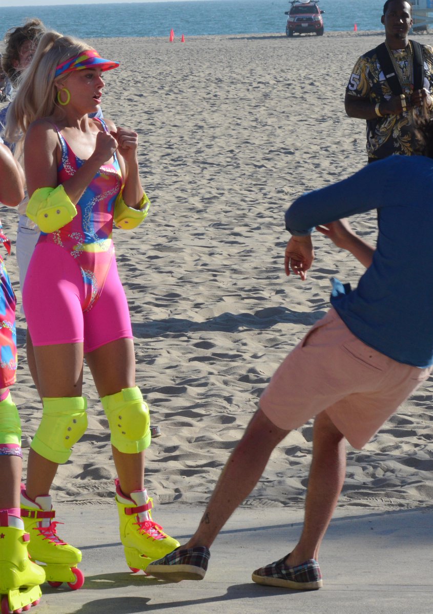mrbrphotos's tweet photo. Margot Robbie filmando uma cena de Barbie em que dá um soco em um homem que a assedia na praia ✨ https://t.co/erAmlGXlLi