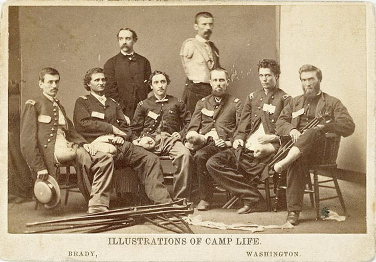 A black and white photo of 8 male, civil war soldiers, all missing legs and arms. They are in uniform & have severed stumps protruding to show the extent of their injuries. It’s a pretty gruesome image.