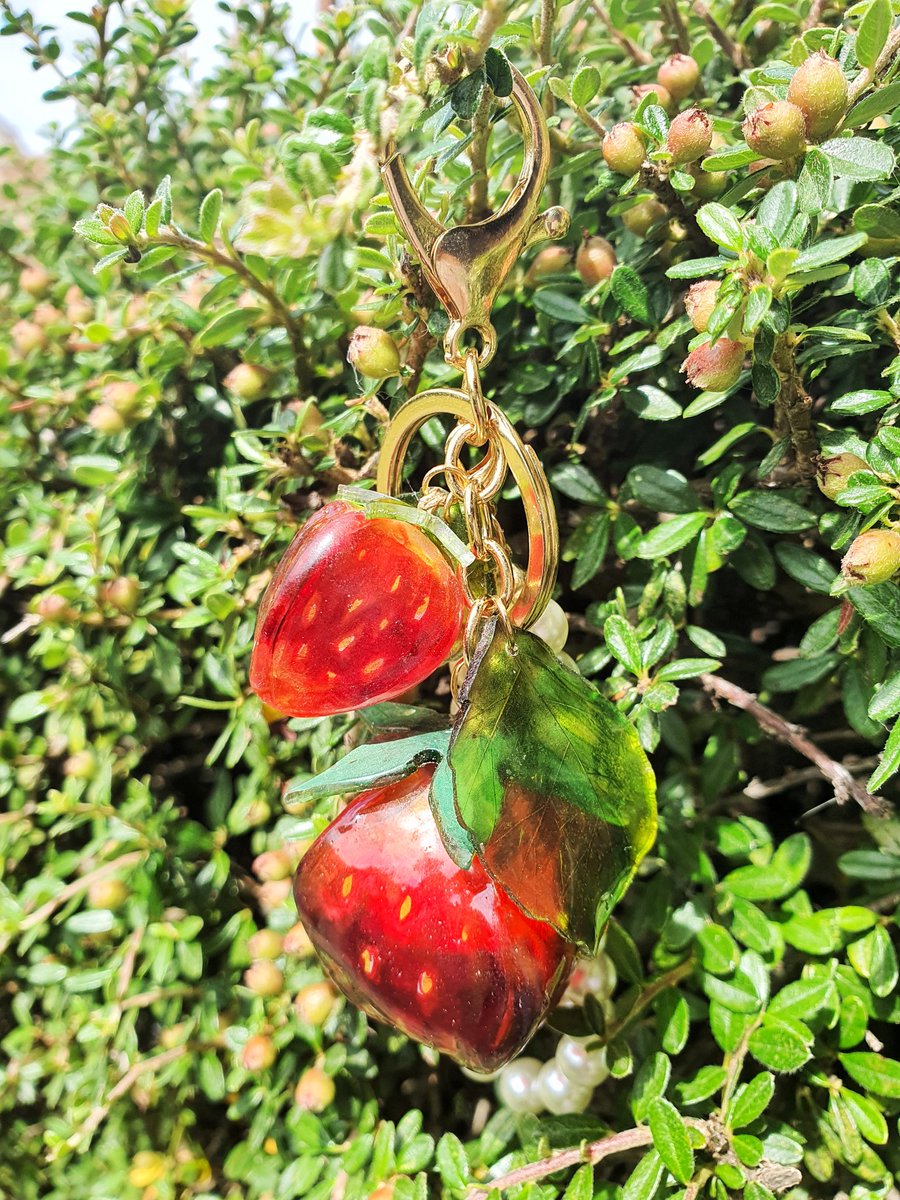 Summer is finally here and with it comes juicy strawberries! Let everyone know you are here with this jingle strawberry keychain. Made from bright red, glittery plastic and painted by hand to look realistic. This unique accessory will be perfect for your keys, belt or bag!