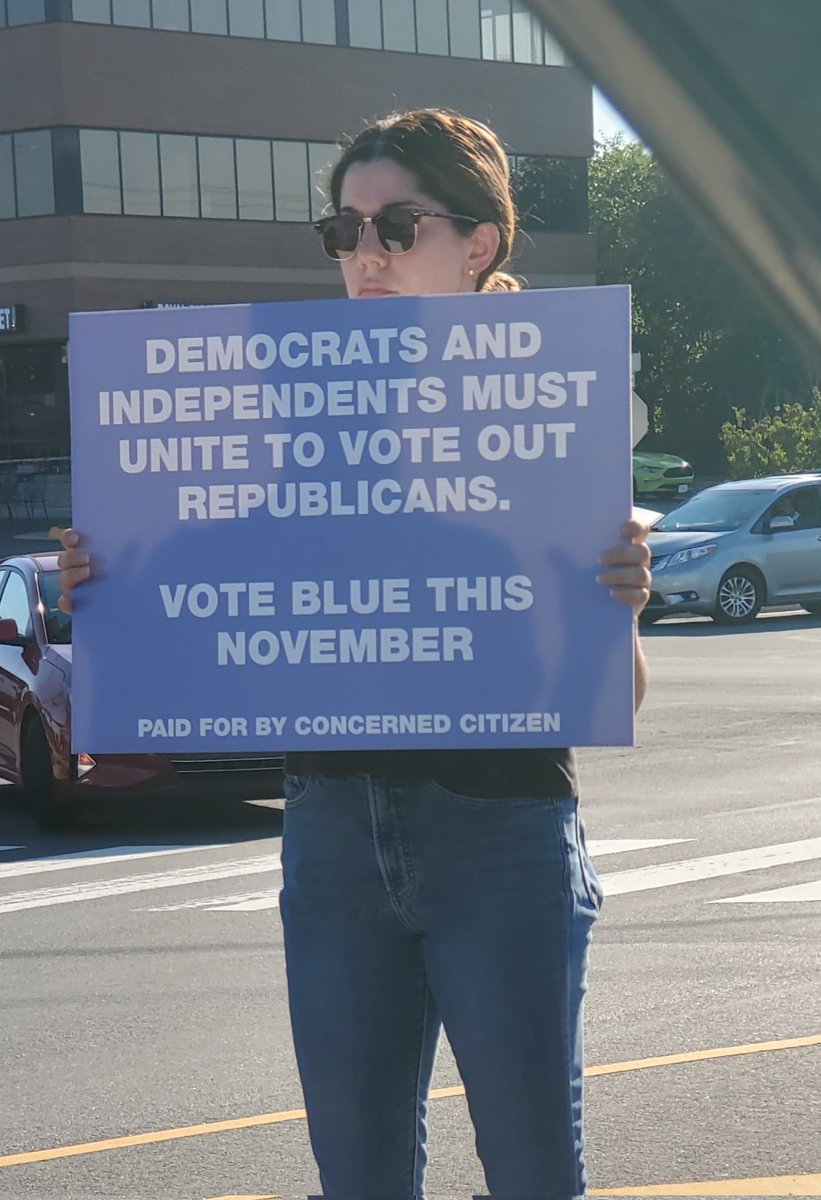 WajahatAli's tweet photo. This lady has been holding this sign at the middle of the intersection, stone cold, not a word uttered. 

I still think the country is underestimating the anger of women and Gen Z. They won't take this sitting down. They won't go back. https://t.co/kfUgK6Y4hS
