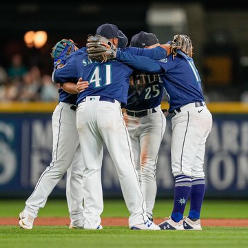 Mariners infield hug after their 8-6 win over the A's.