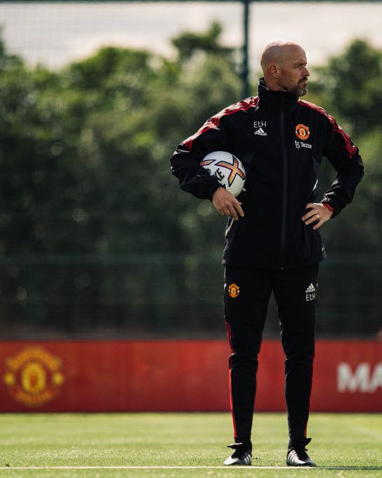 Erik ten Hag watches on in training at Carrington, while holding the official 2022/23 Premier League ball under his right arm.