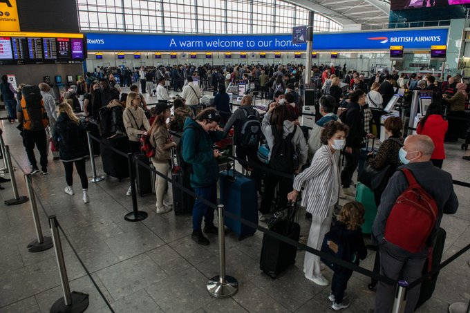 Passengers queue to check in