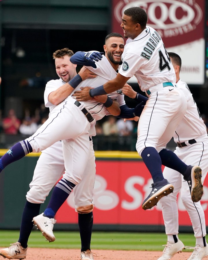 Cal Raleigh, Abraham Toro and Julio Rodríguez celebrate a walk-off win.