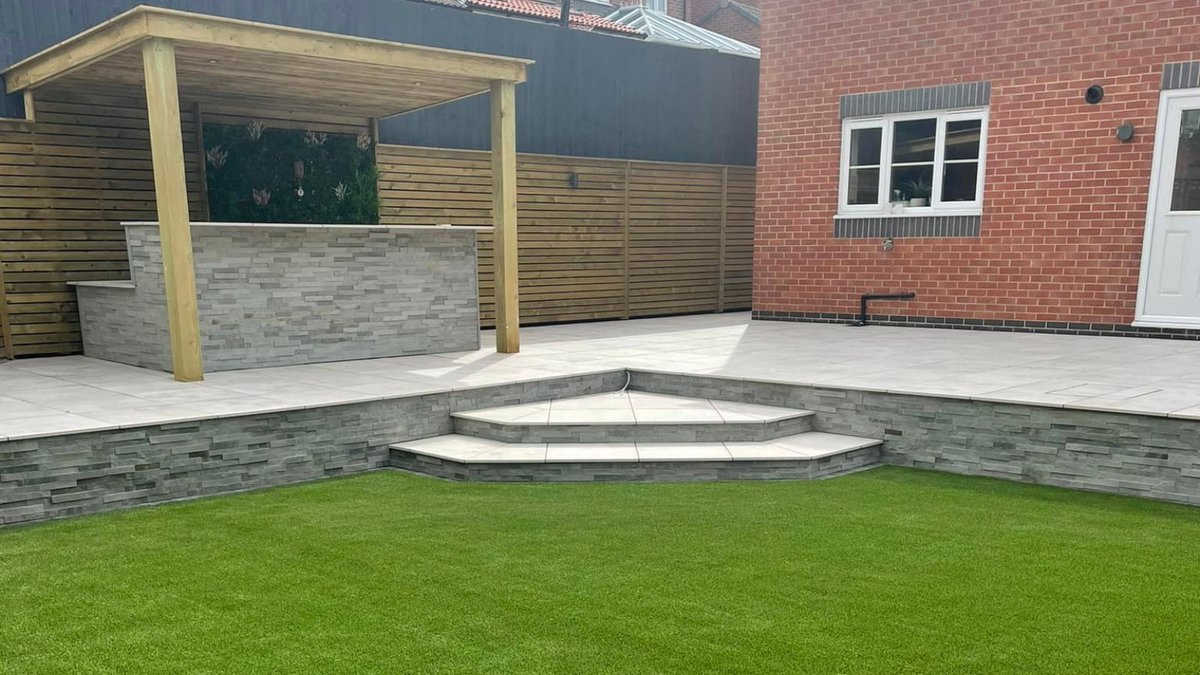 BradstoneUK's tweet photo. Our #qualityassured landscaper Harris Hard Landscaping completely transformed this garden into the perfect entertaining space using our manzano porcelain paving and stone walling slips, we can just imagine enjoying summer evenings here 😍 #gardenlandscaping #gardendesign https://t.co/ygOgCxI7XR
