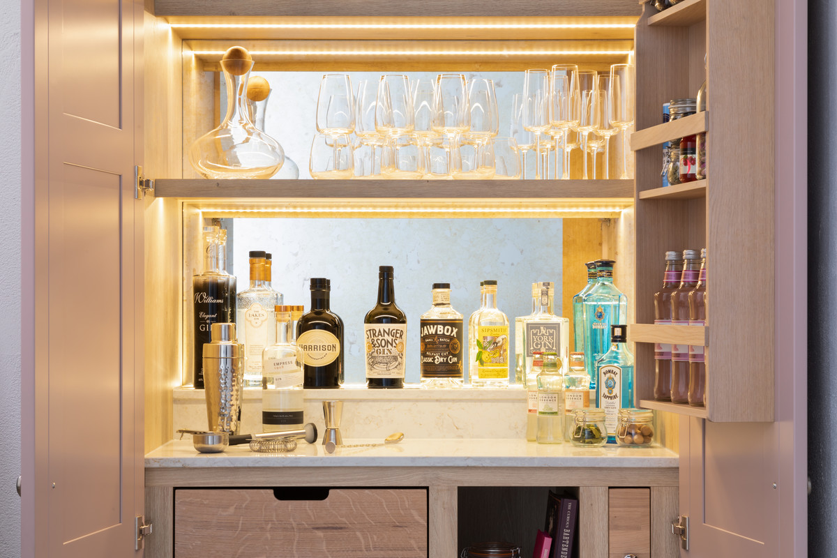 This bespoke cabinet has a range of luxurious finishing touches including a quartz worktop and antique mirrored-glass splashback. 📷 @1909_Kitchens & @paullmcraig #frederickgeorgekitchens #bespokekitchen #shakerkitchen #drinkscabinet #gin #pinkkitchen