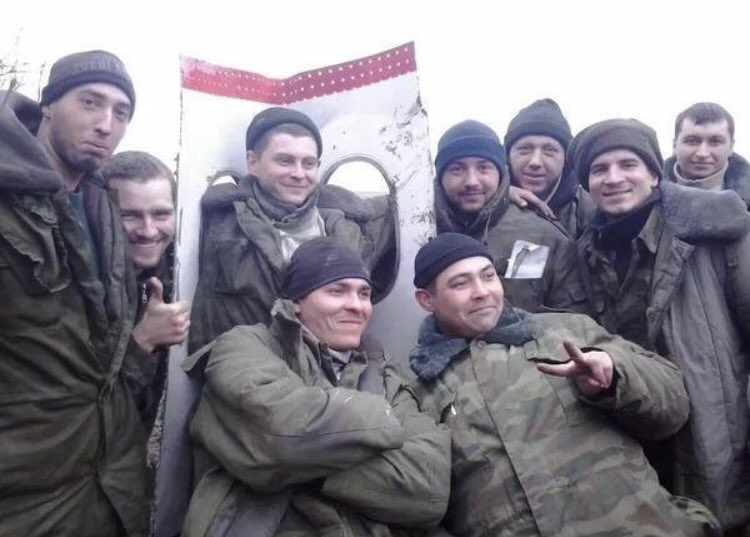 visegrad24's tweet photo. Russians celebrating in front of the wreckage of MH17 after shooting it down over Eastern Ukraine on July 17th 2014.

298 civilians were killed by the missile that had been provided by the Russian Army. https://t.co/zqe7rcR965