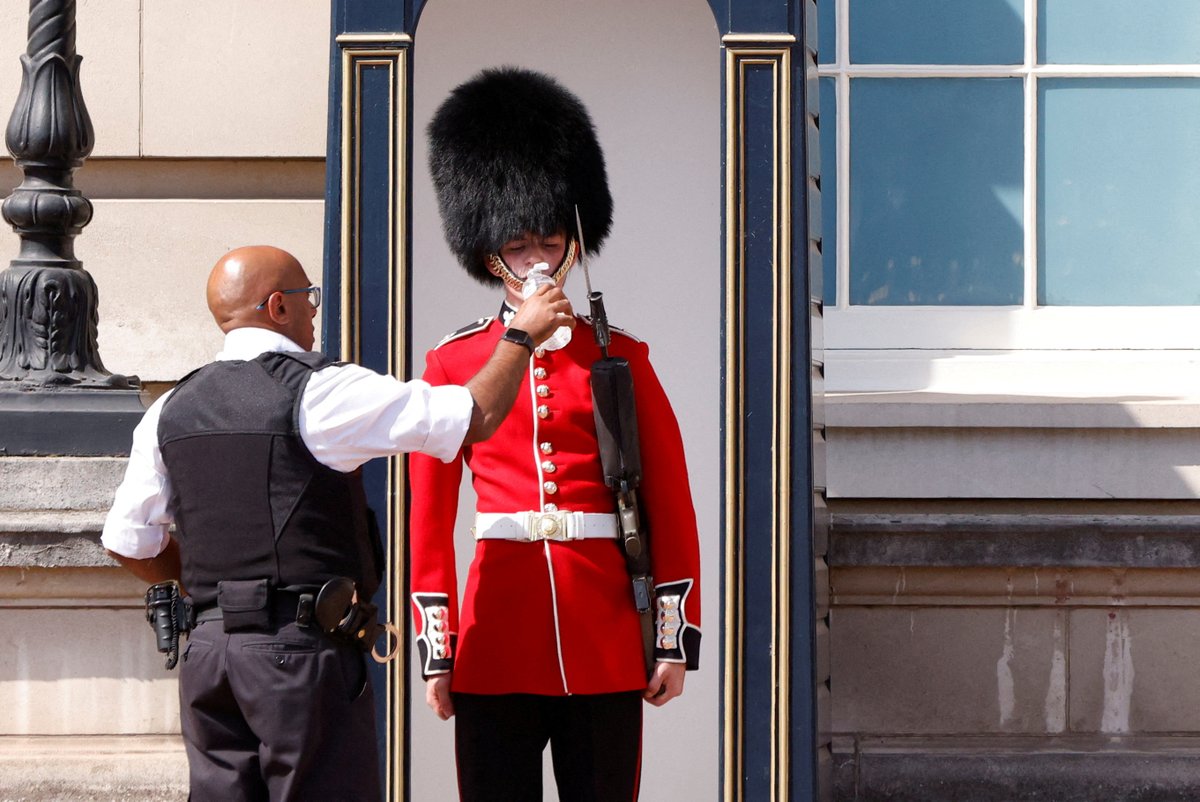 CameronDLWalker's tweet image. If you're struggling in the heat, spare a thought for members of The Queen's Guard 🥵

A member's been pictured being given a drink of water outside Buckingham Palace as temperatures soar to 36°c in London☀️

📸Reuters