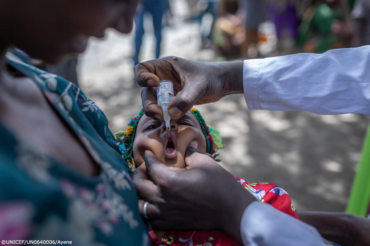 A baby is vaccinated while being held by his mother