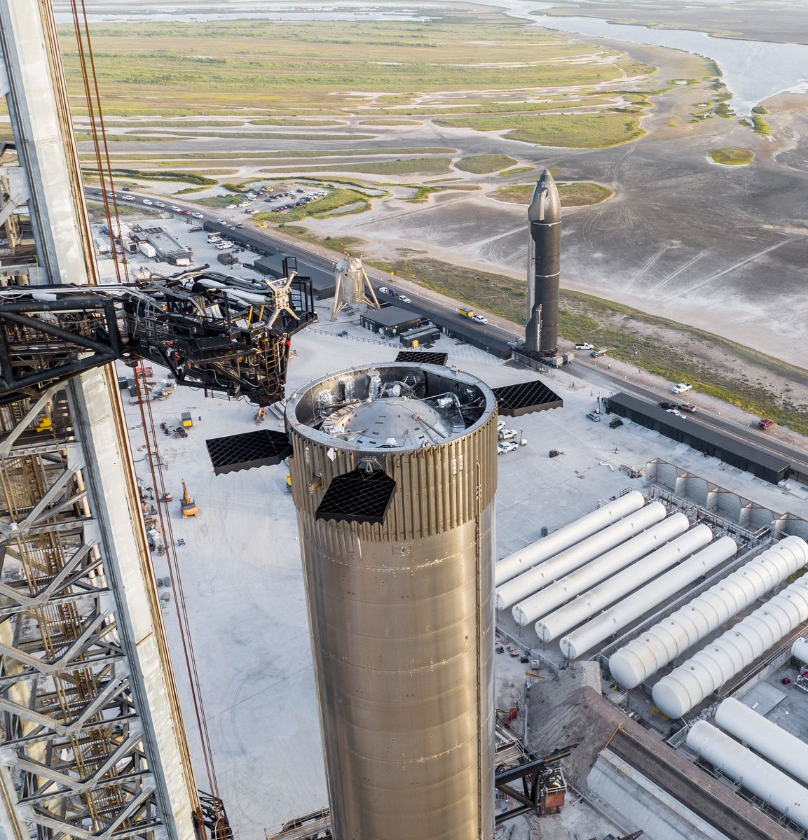 PPathole's tweet photo. SpaceX Starship is fucking big. Nearly 400 feet tall, it's the height of a 40-story skyscraper. It's more than 3x mass &amp; generates 3x the thrust of Saturn V. It's the biggest and most powerful rocket humanity has made. And to top it all off it's fully reusable 🤯 @elonmusk https://t.co/Elo9lfDtMU