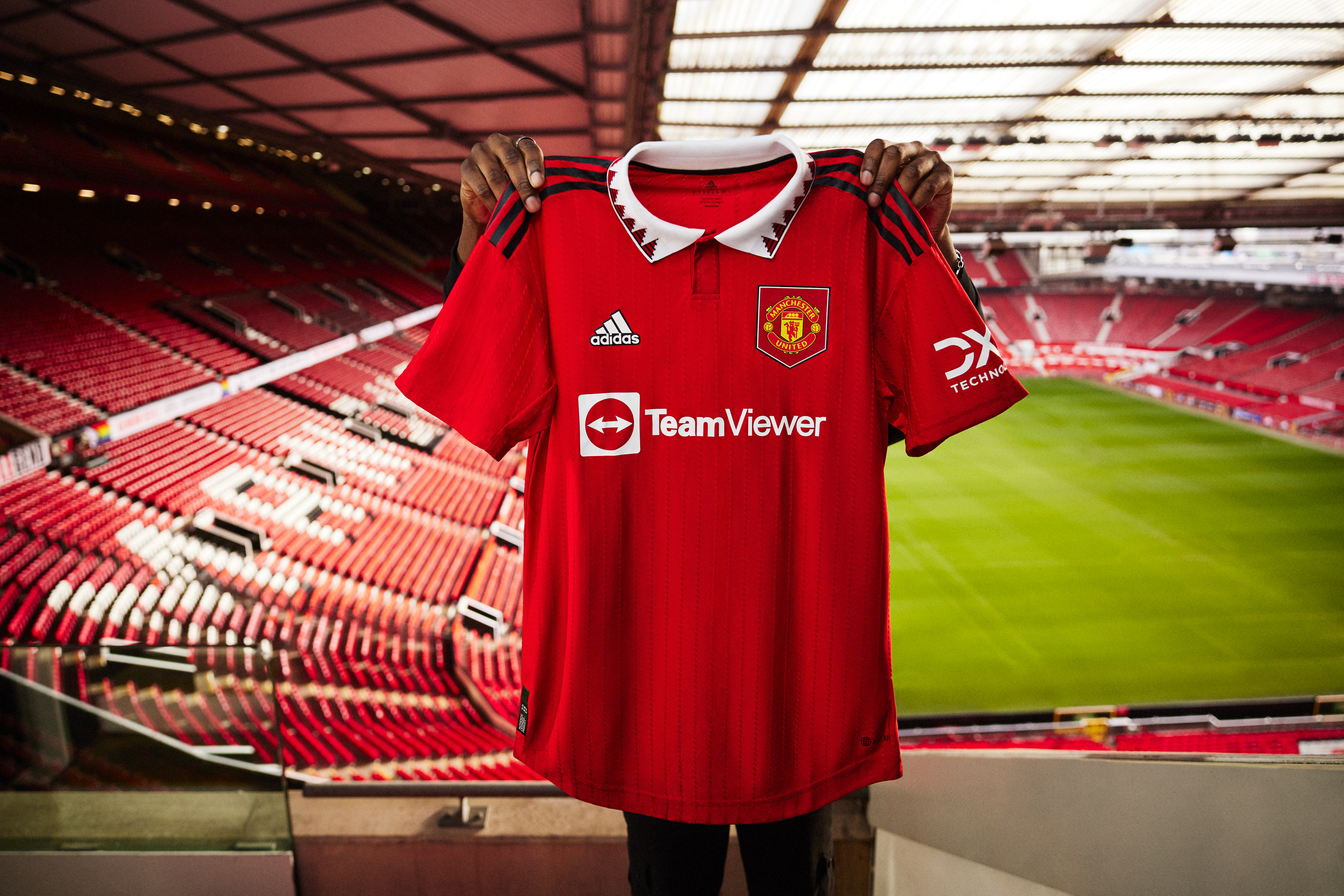 Our 2022/23 home shirt is held up inside Old Trafford.