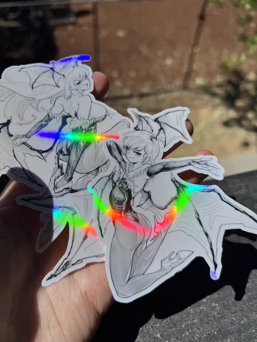i got some holo stickers of Morrigan and Lilith at my merch shop and honestly they turned out amazing. please, check them out! (link in replies) 