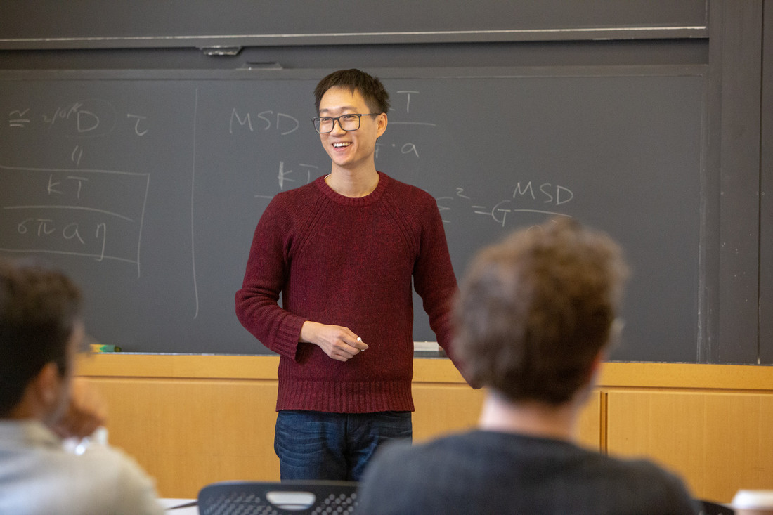 Ming Guo teaches in front of chalk board