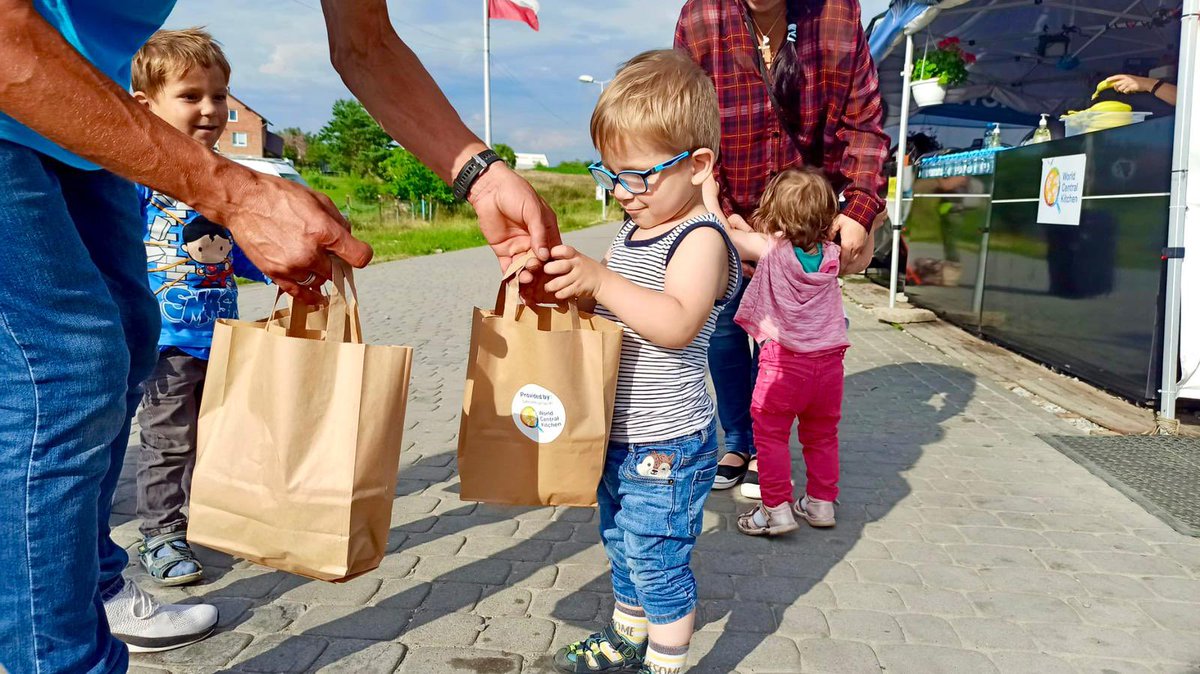 WCKitchen's tweet photo. More than 4 months into the invasion of Ukraine, WCK continues providing meals to refugees arriving in Poland. At the border, we hand out travel bags for kids to take with them as they continue farther into Poland—each bag contains a sandwich, fruit, juice &amp; 🍫! #ChefsForUkraine https://t.co/fTEjEyMRnX