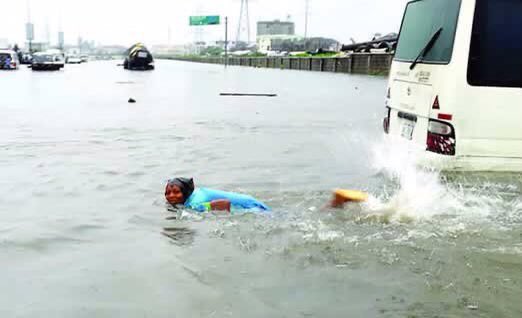 Boy swims in flooded road