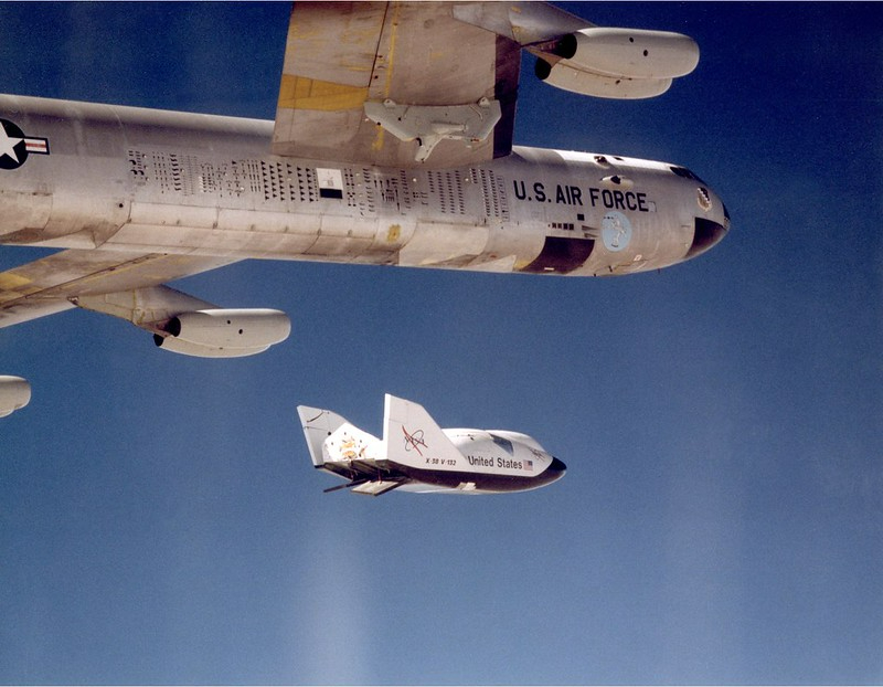 NASAhistory's tweet photo. The X-38 Ship 2 prototype drops away from NASA's B-52 mothership in this photo taken #OTD in 1992. The X-38 crew return vehicle (CRV) was designed as an emergency crew return vehicle for the @Space_Station, but the program was cancelled in 2002 due to budget cuts. https://t.co/zMYRgIgBCw