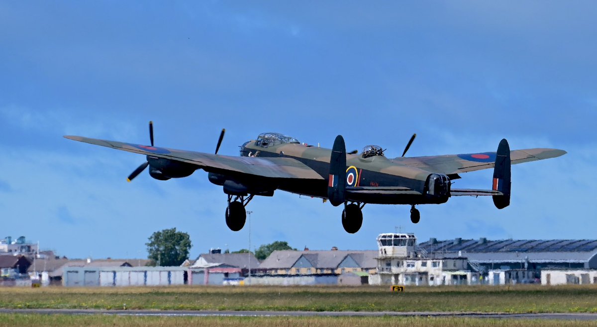 BlackpoolAviat1's tweet photo. BBMF Avro Lancaster departing Blackpool Airport to display at the Southport Airshow (note the airport’s historic WW2 control tower, still in use to this day - in the background) … two fitting tributes to that era, side by side. https://t.co/X0MlCUTb1K