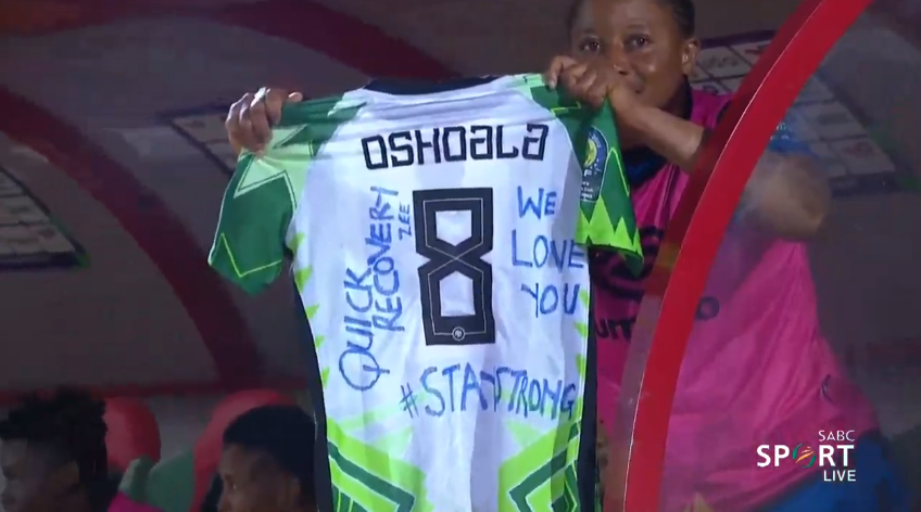 Foetbal247TBG's tweet photo. Tochukwu Oluehi holds up a shirt with a message for the injured Asisat Oshoala #WAFCON2022 #TotalEnergiesWAFCON2022 #NGABDI https://t.co/IQnT2IKgS8