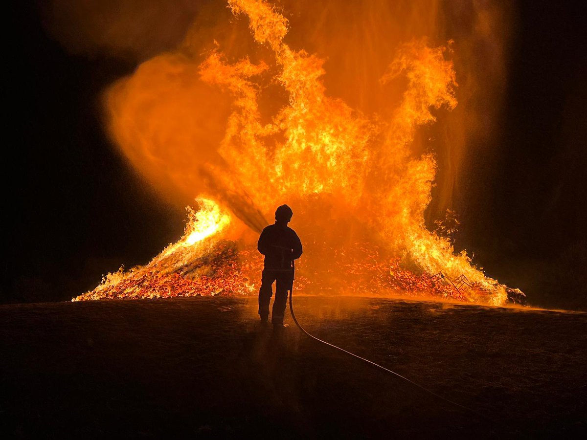 DownpatrickFir1's tweet photo. Newcastle Firefighter cooling down an 11th night bonfire in Dundrum to protect nearby residential properties from heat damage. #nifrs #nifrsfamily #community #dundrum #firefighters #fire @BBCnireland  @UTVNews https://t.co/Tc958fhfDb