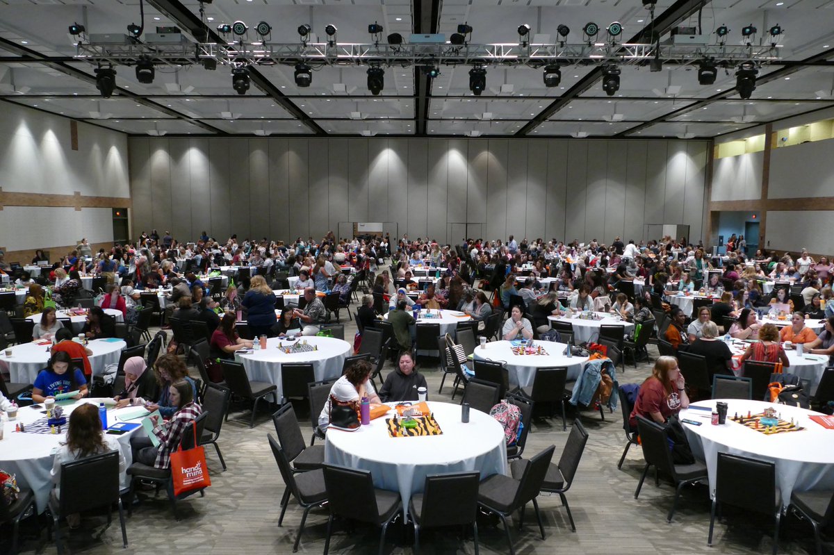 A room full of people sitting at tables