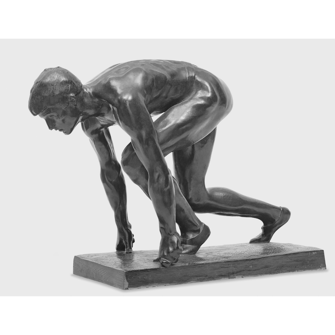 A bronze sculpture of a man crouched down and ready to run.