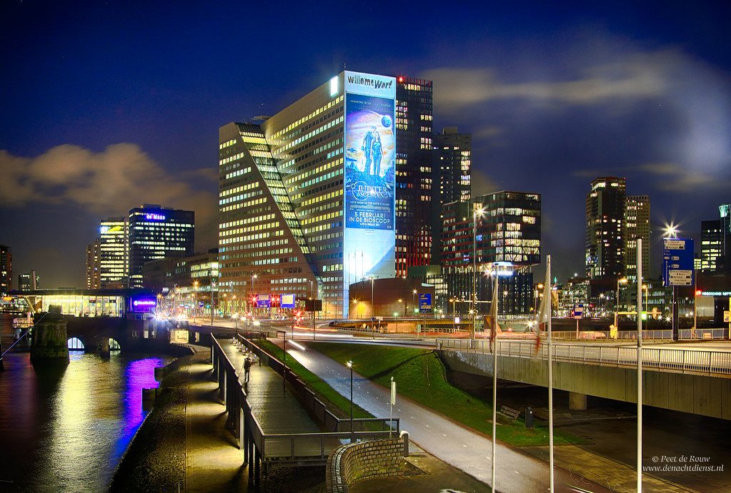 JohnKuijt's tweet image. Quists zichtbaarste en daarom bekendste werk is het kantoorgebouw Willemswerf uit 1988, een ruim 90 meter hoge doos aan de Maas in Rotterdam die wordt doorkliefd door een diagonale wig. #Quist #RIP