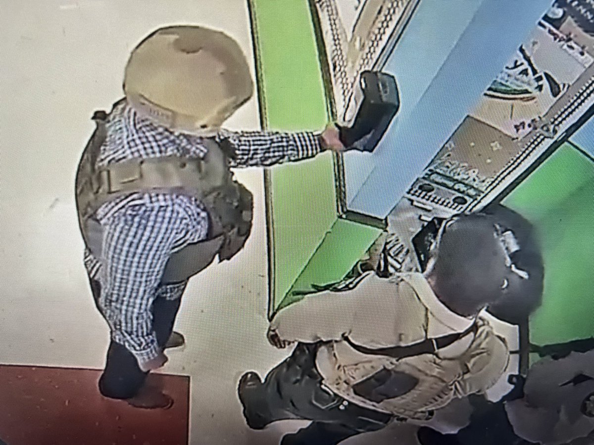 A police officer gets a squirt of hand sanitizer while 19 children and two teachers were murdered at Robb Elementary School in Uvalde, Texas