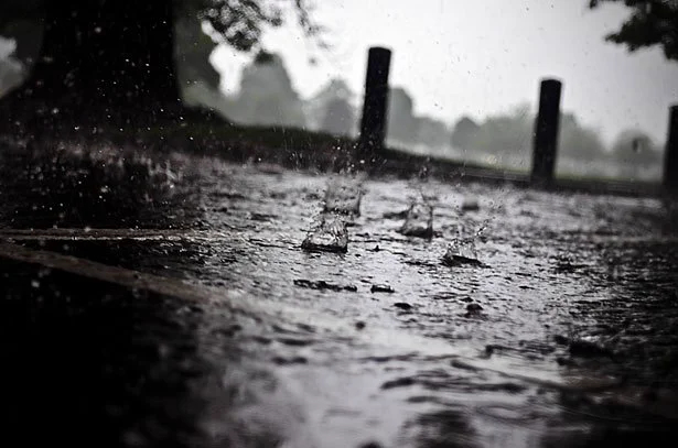 Heavy rain hitting the pavement during a rainstorm.