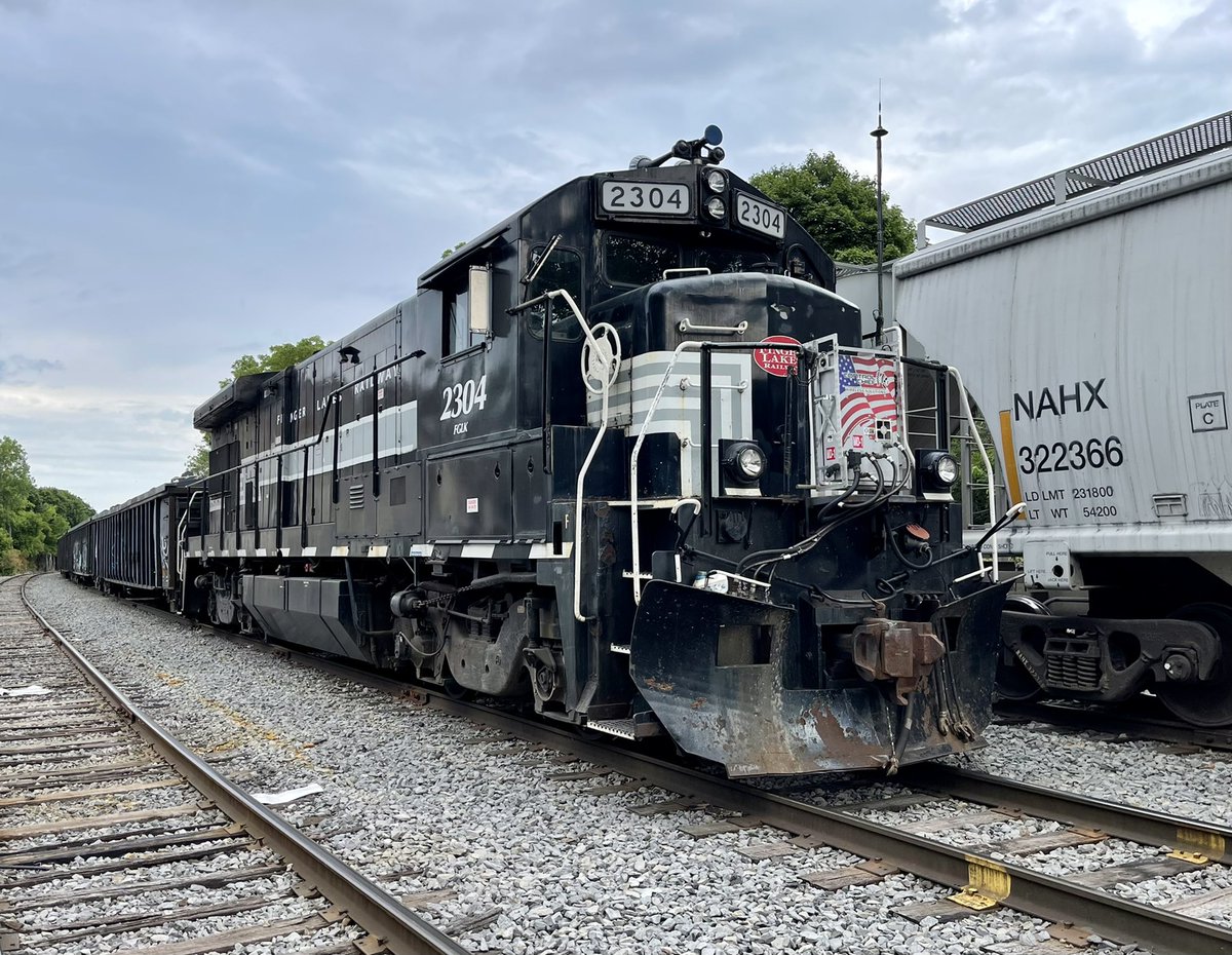 CayugaValley's tweet photo. FGLK B23-7 #2304 is tied on to the headend of a block of gondolas to be picked up by the westbound GS2 (Sweep Train) this evening. 2304 will be brought back to Geneva, and another locomotive will be dropped off to replace it as AY1 (Auburn Yard Job) power. M.A.Fritz Photograph. https://t.co/BYeKBSziTY