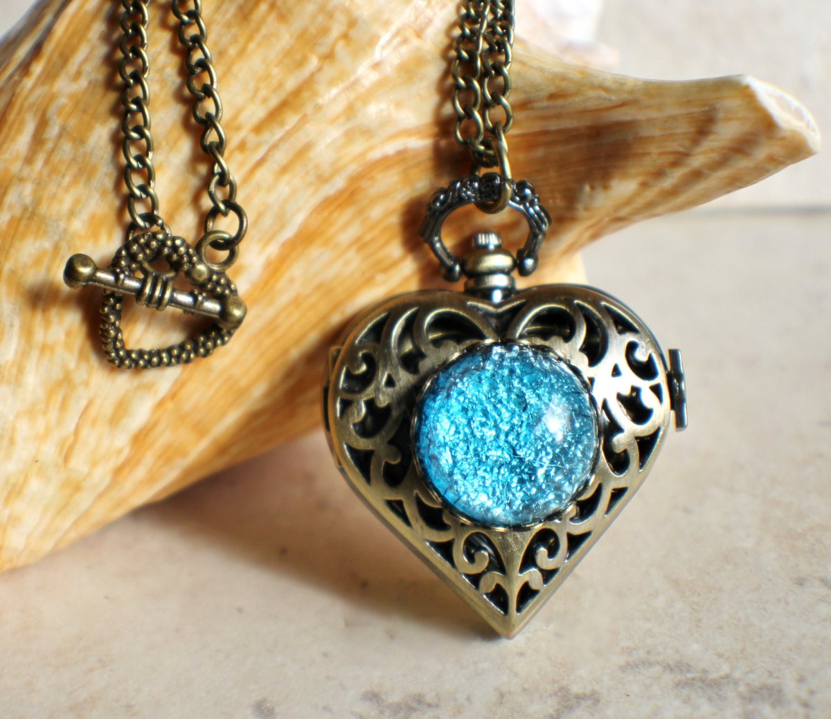 Heart watch locket with blue glass fire opal on front cover in bronze. tuppu.net/f84214ca ##pottiteam #Etsy #Handmadejewelry #Charsfavoritethings #BlueGlassOpal