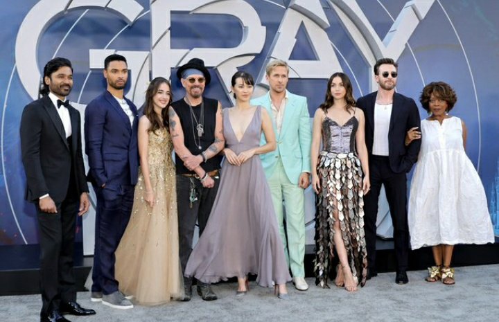 El elenco de #TheGrayMan posando en la alfombra gris de la premiere en Los Angeles