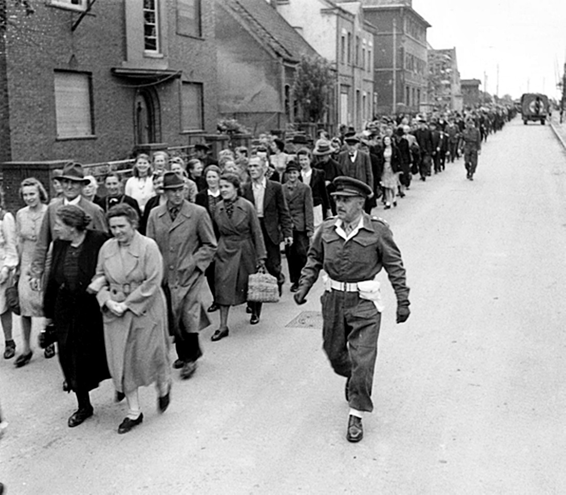 Денацификация немцев. Германия 1945 г. Американские военнослужащие организованно ведут немцев в кино для показа преступлений нацистского режима Гитлера.