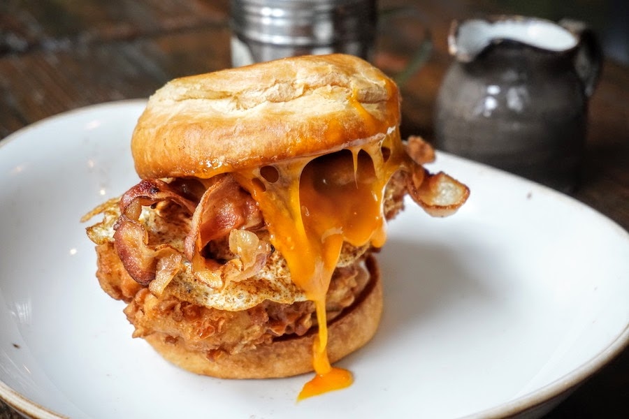 Say it 3 times fast: Pretzel Crusted Maple Bacon Chicken Sandwich! In case that wasn't enough, this sammy's got melted cheddar cheese, fried egg, whipped honey butter, coop sauce &amp; powdered sugar. Get at it! 💛😜 #MADBrunch