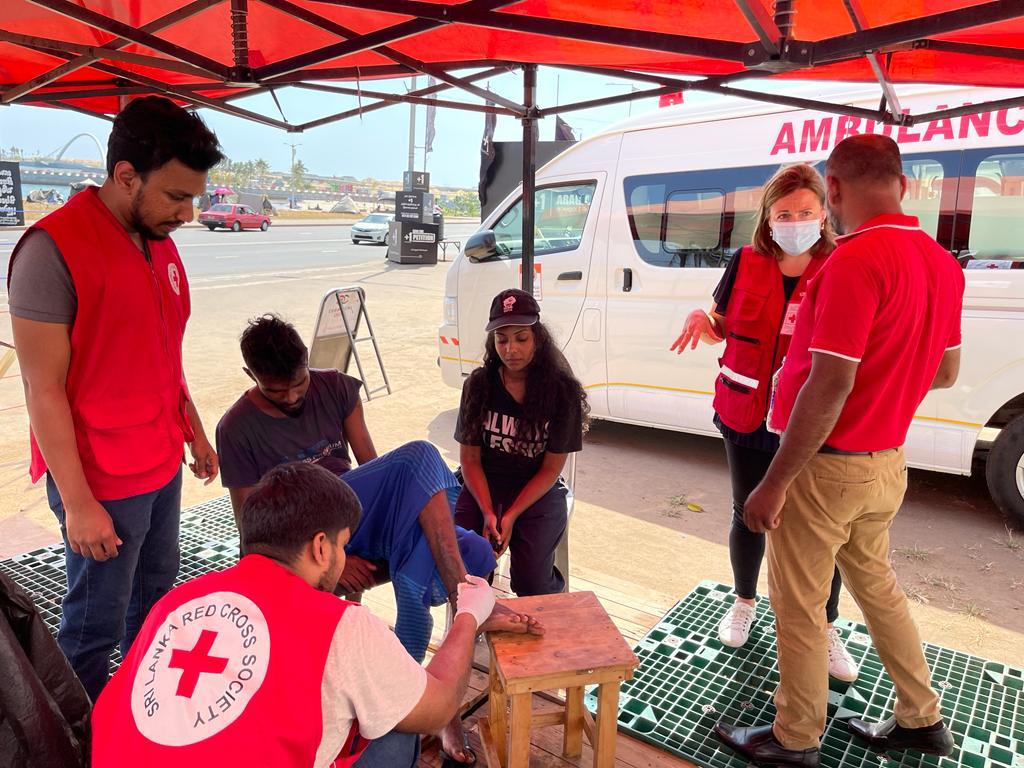 RegmiUdaya's tweet photo. #redcross volunteers in action in Colombo at the site of the #SriLankaprotest. They have cared for thousands of injured in recent weeks as first responders. But #SLredcross is providing so much more - CASH assistance and medicines @IFRC to those worse hit by the economic crisis. https://t.co/arjA3vjsDs
