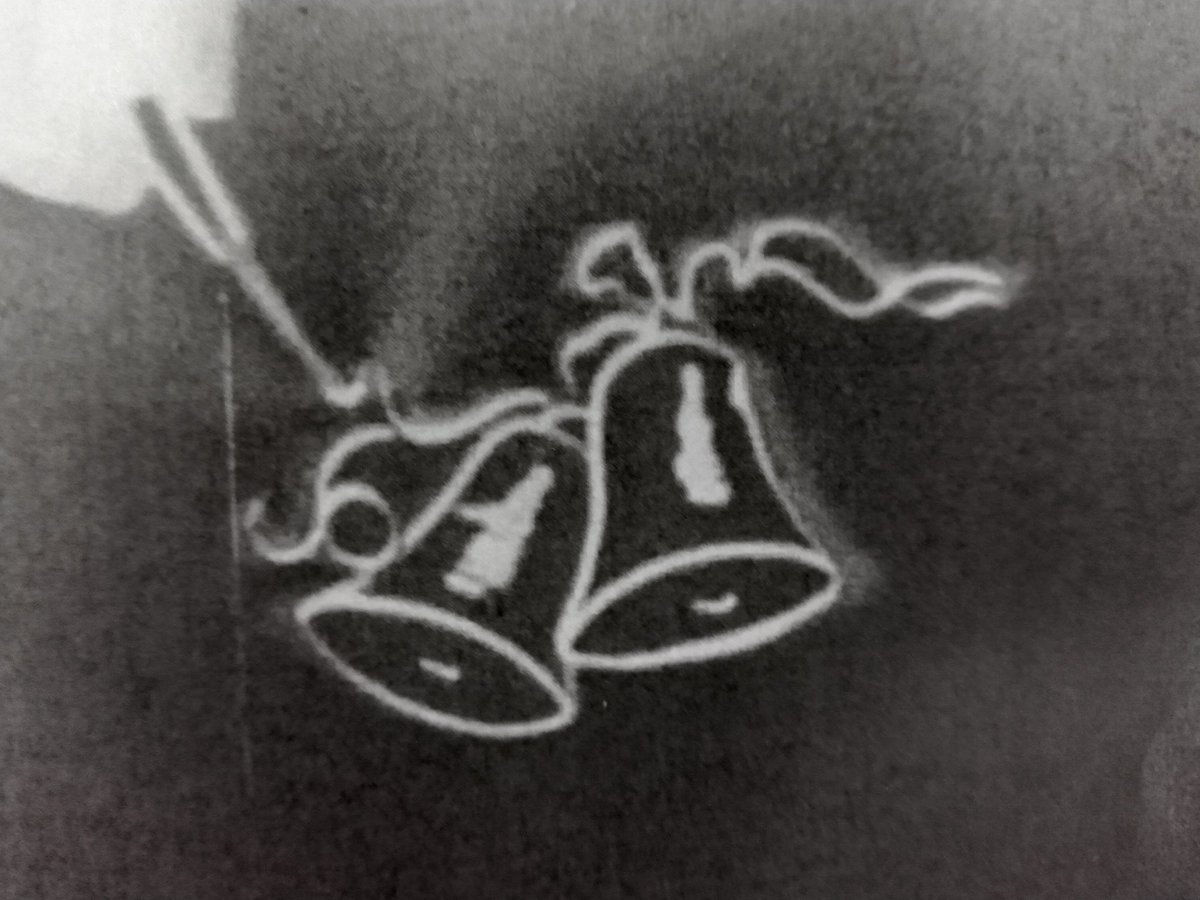 yhennessy's tweet photo. A single frame from one of Ireland's oldest surviving animations (c.1938) Accidentally capturing the fingers of the animator and her tiny tool used to move the paper cutout bells. https://t.co/Cfrx9aAzoK