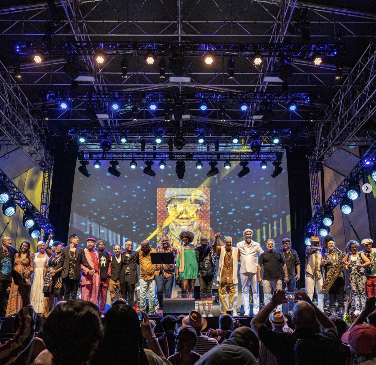 nettieb's tweet photo. On Sunday, we celebrated the life and legacy of musician and writer Greg Tate with @burntsugararkestra and @Photoville presented a pop-up exhibition in honor of Tate. 

My portrait of Greg Tate was looming over the stage from behind everyone. <3 https://t.co/YJecuNFuI4