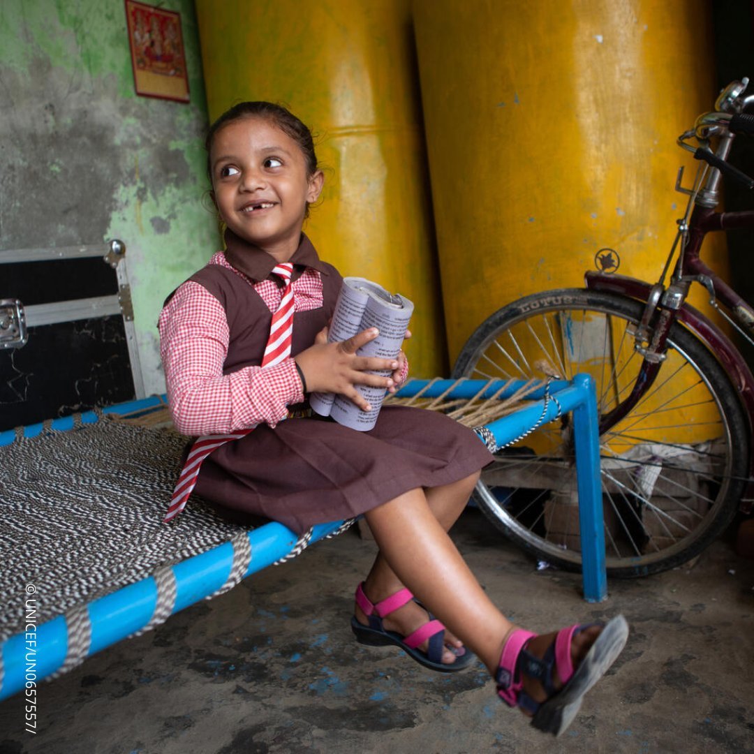 Ankita holding a book with a big smile on her face.