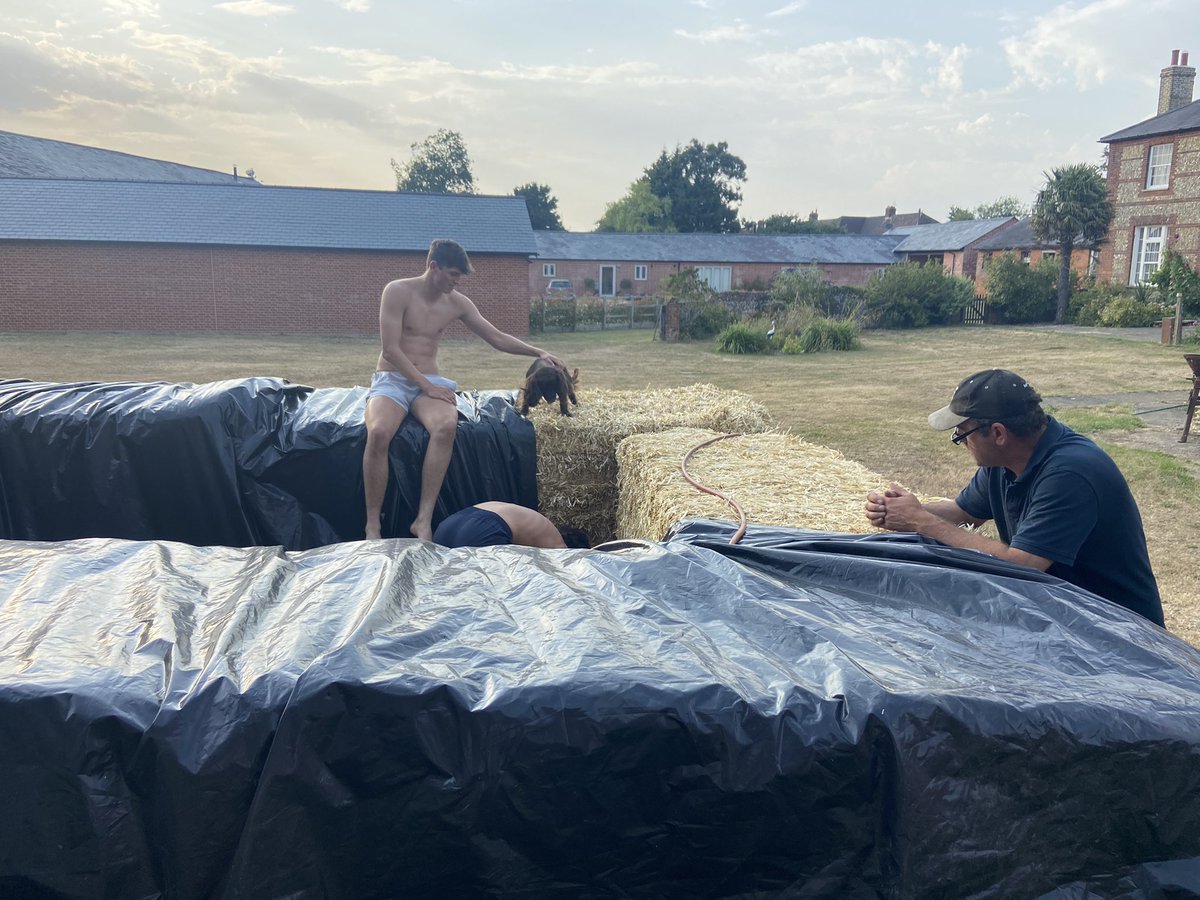JemmaLWJ's tweet photo. @GeogFelsted 39deg in Great Chishill.  Too hot to harvest as the grain moisture % was too low to sell and the risk of fire in tinder dry fields with hot machinery was too great. So, like many farmers, we built a pool from straw bales to cool off. https://t.co/UVhOhh5F5E