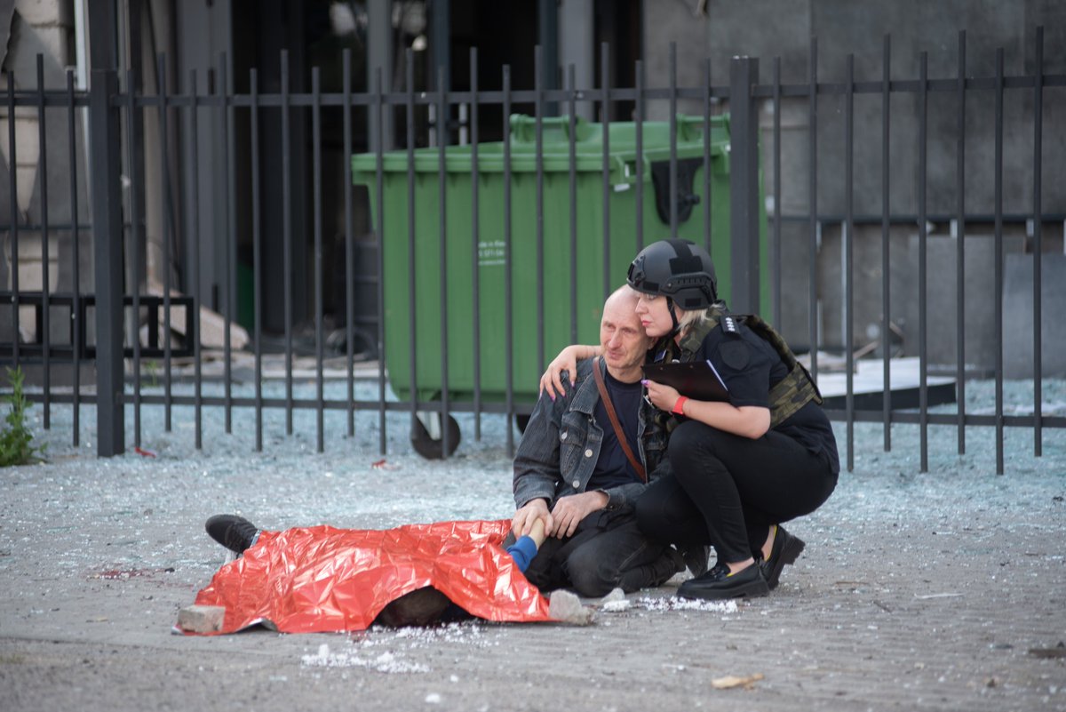 Un hombre cierra los ojos del cuerpo de su hijo asesinado en la ciudad de #Kharkiv por un misil ruso, esta mañana. En la segunda imagen, es consolado por una mujer policía.  #Ucrania #RusiavsUcrania <a href="/ZelenskyyUa/">Volodymyr Zelenskyy / Володимир Зеленський</a>