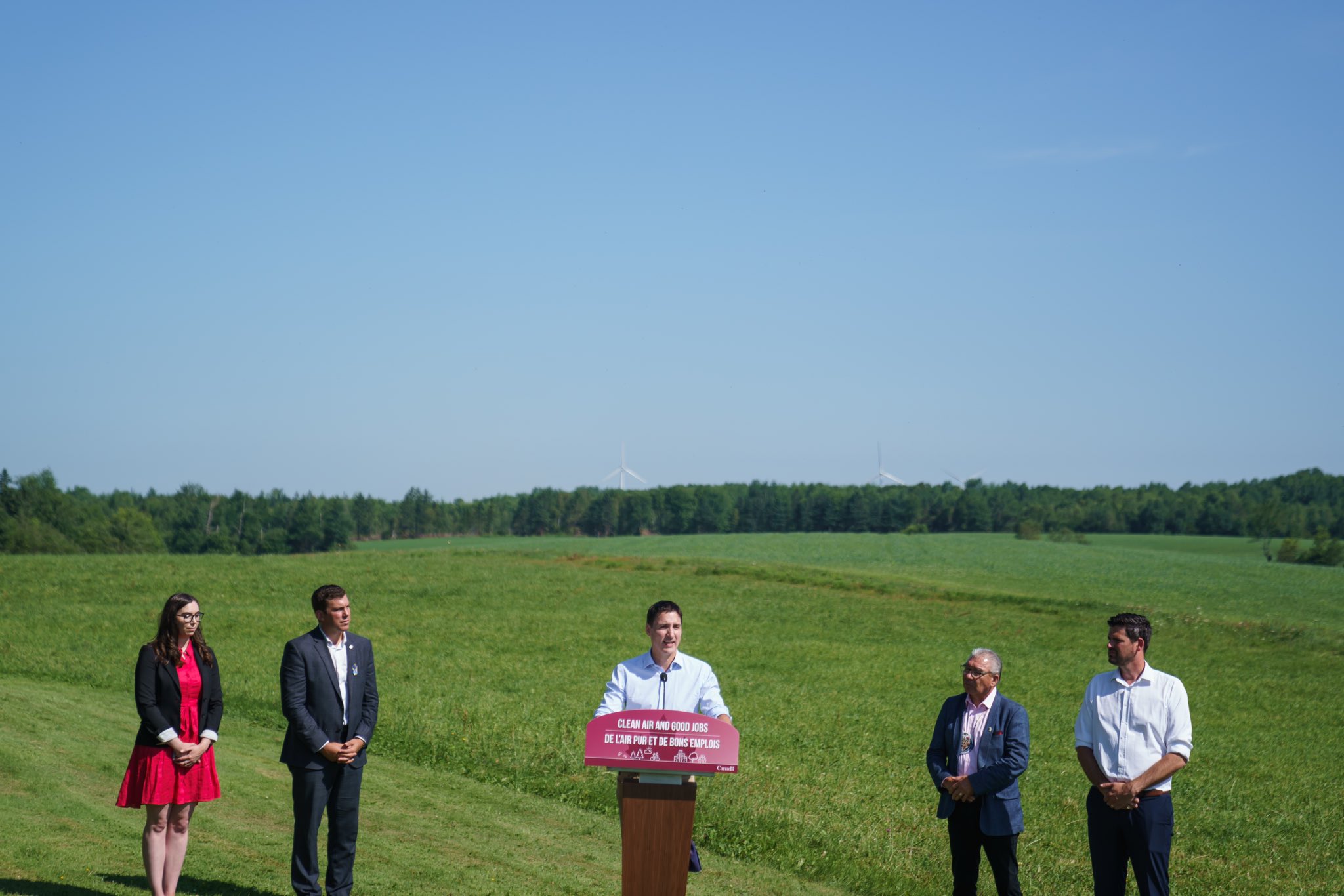 Prime Minister Justin Trudeau is standing at a podium outdoors. Chief Sydney Peters, Member of Parliament Kody Blois, Minister Sean Fraser, and SWEB Development Manager Sarah Rosenblat are standing behind him.