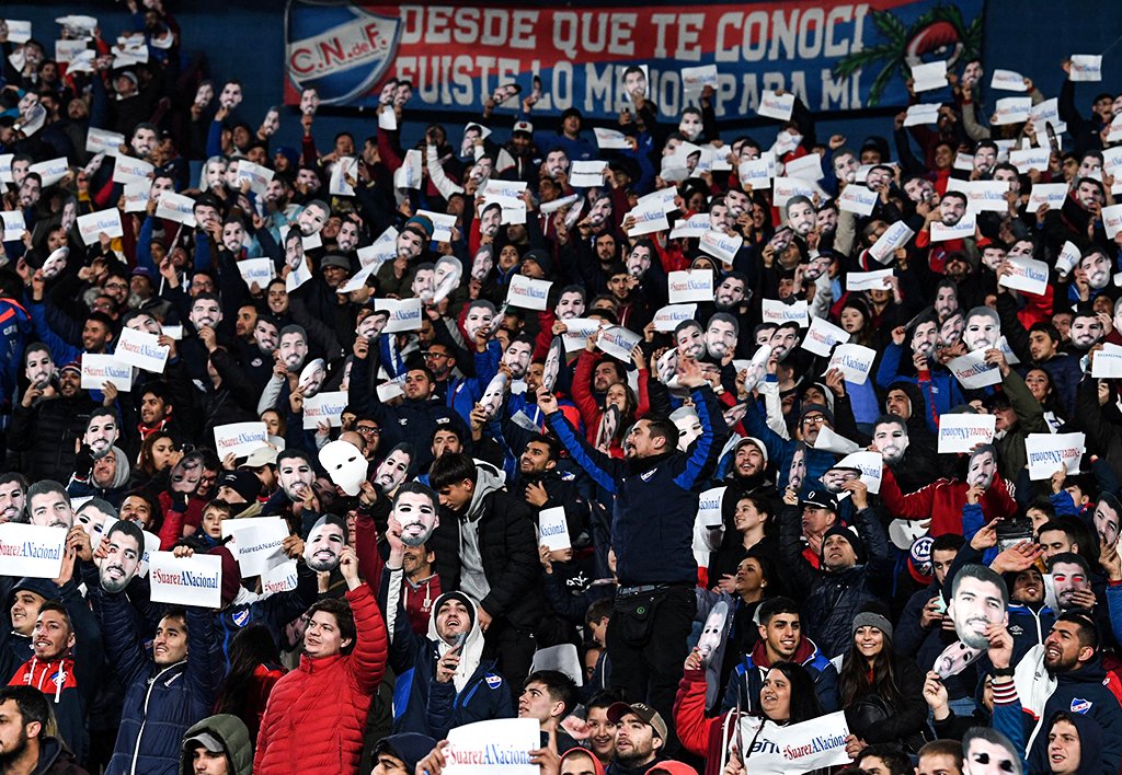 brfootball's tweet photo. ‘He doesn't arrive, he returns'

20,000 Nacional fans wore Luis Suárez masks during a game on Thursday with the striker reportedly close to a return to his first club 🇺🇾 https://t.co/IUZtBlkuRF