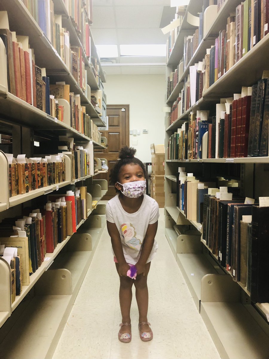 JoyEllenW's tweet photo. At the rate we’re going, my child will know how to use a book cradle and submit a Gaylord order by the time she’s five 😂😂 I love bringing her to work with me when I can! #rarebooks #specialcollections #workingmoms #raisedinthestacks https://t.co/0nGmB3agxl