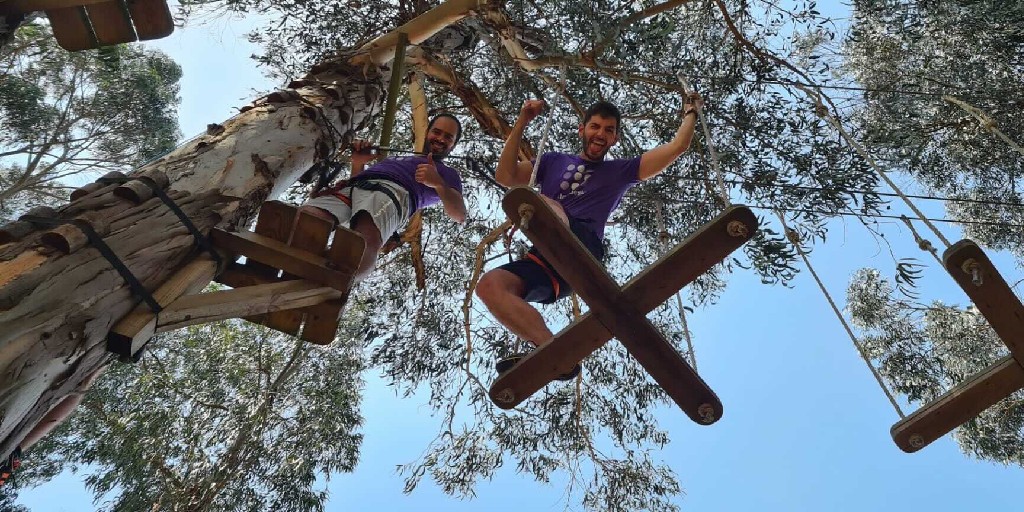 Talkdesk's tweet photo. #Talkdeskers during a #teambuilding activity helping each other through a ropes course in the trees. 🌳 💜 #lifeattalkdesk https://t.co/uSqpnVTQVR