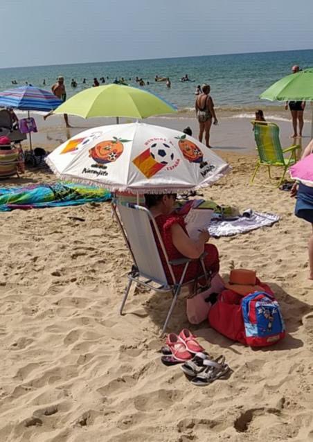 Un fuerte aplauso a esta sombrilla vista hoy en la playa de la Barrosa, en Chiclana.