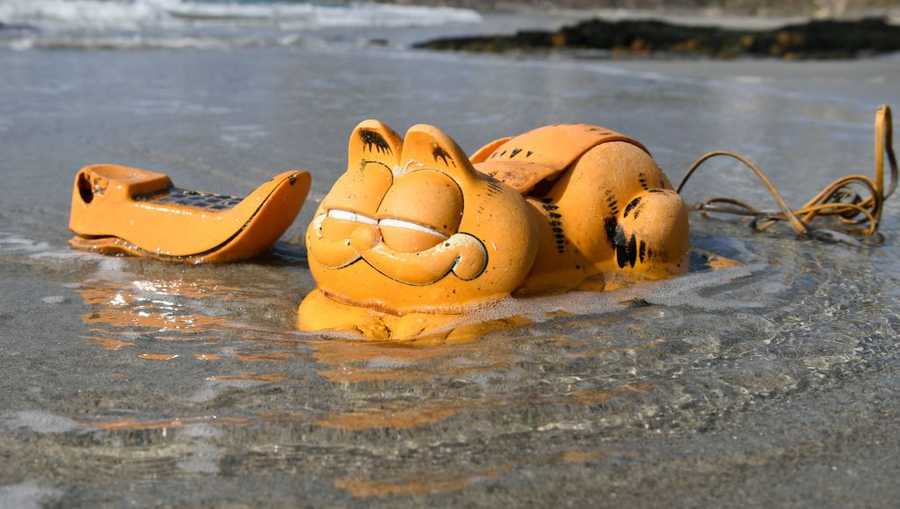 historydefined's tweet photo. Garfield phones have been washing on the shore of the Finistère coasts of France for almost four decades. There's a shipping container wedged in the rocks that has been slowly releasing them all these years. Photo by Fred Tanneau. Source: https://t.co/6ESIdfdw0J https://t.co/rckHQkrDiu