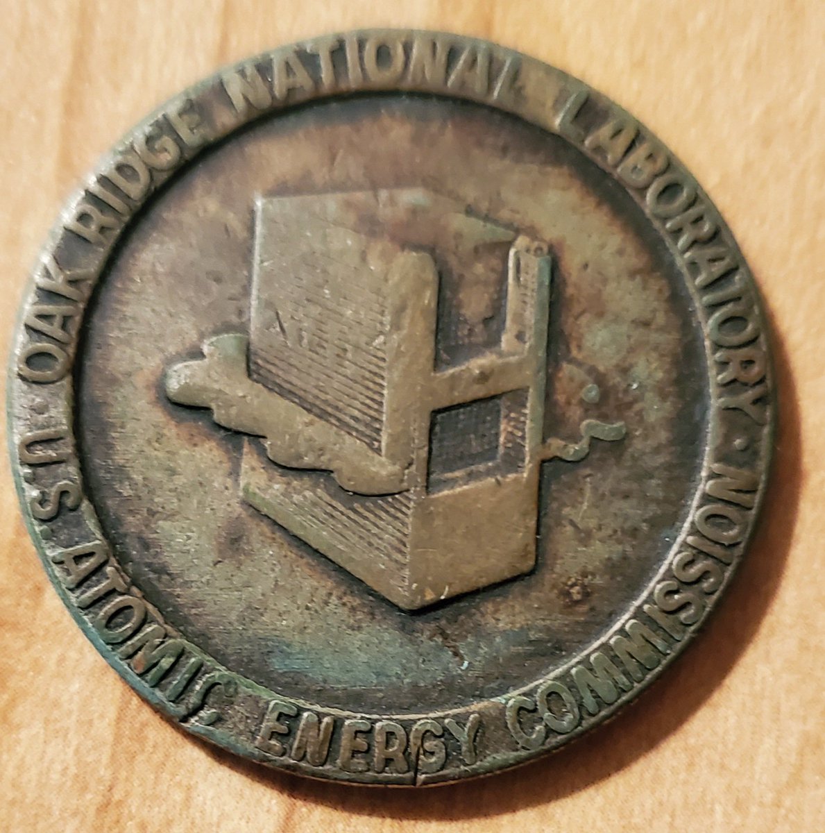 news38555's tweet photo. A heavily loved token of the ORNL experiment to generate power from a nuclear reactor Feb. 24, 1953. Better ones I've seen had a loop for a Keychain on top. Graphite Reactor logo on front. Union Carbide Nuclear Corporation on obverse. My collection. https://t.co/8Levvc5lcV
